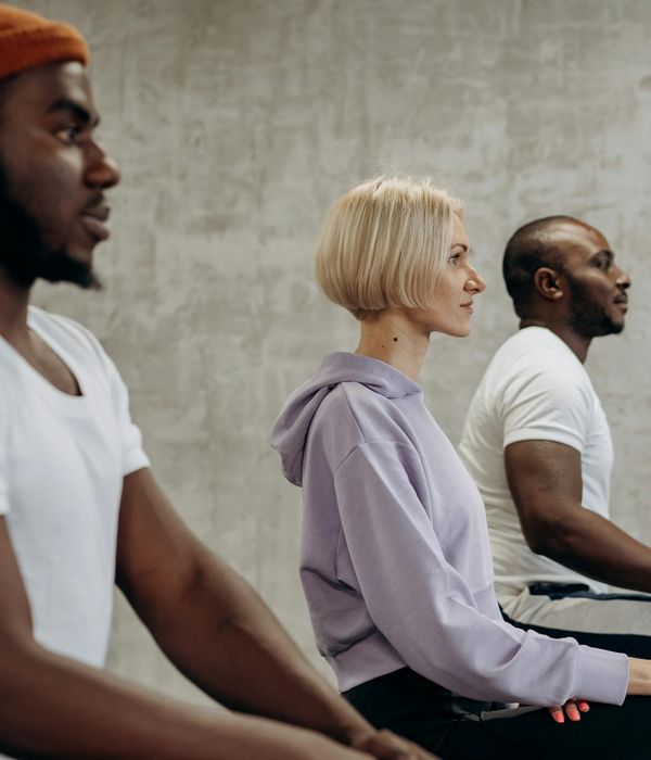 A group of diverse athletes meditating after a yoga session, looking calm and focused.